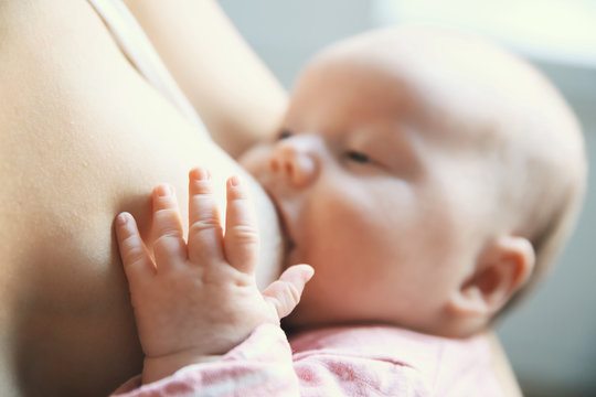 Mother breastfeeding newborn baby child