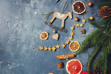 Cozy christmas background with dried oranges, fir tree, warm mittens, cinnamon and cones