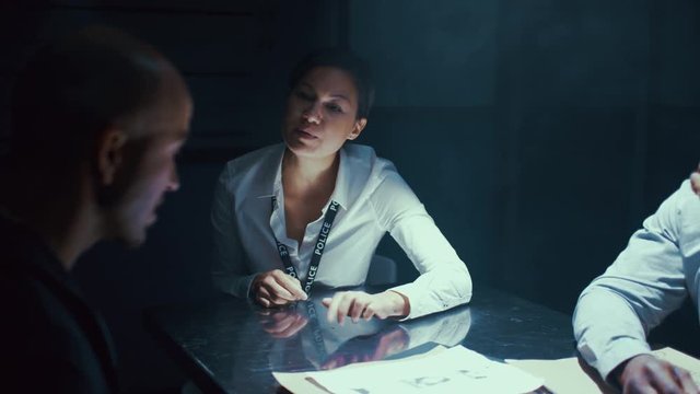  Detectives giving tough questioning to crime suspect at police station