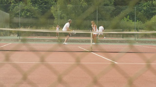  Tennis coach working with female client on outdoor court in the summer