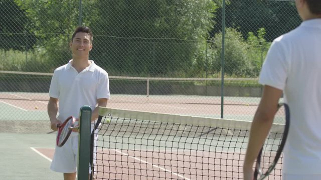  Male tennis player takes a break from game to get his breath back