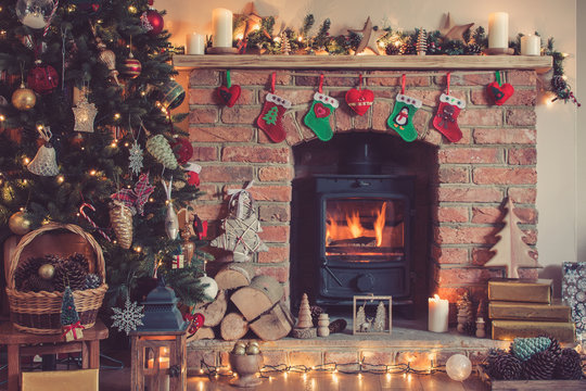 Christmas setting background, decorated Christmas tree, pine cones in the basket with fireplace on the background, candles an baubles, selective focus