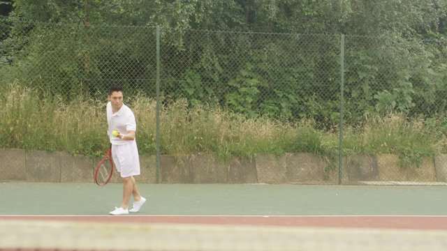  Male tennis player playing against unseen opponent on outdoor court 