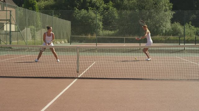  Female doubles tennis players scoring a point during match
