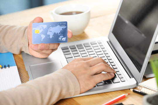 Man using credit card and laptop for online shopping