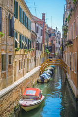 Traditional narrow canal with gondolas in Venice, Italy
