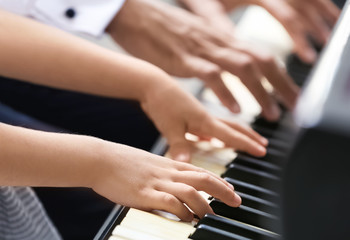 Young man and little girl playing piano, closeup