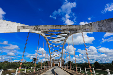 Old white bridge, bright sky and river in Thailand, beautiful background 