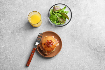 Plate with pancakes and bacon on table