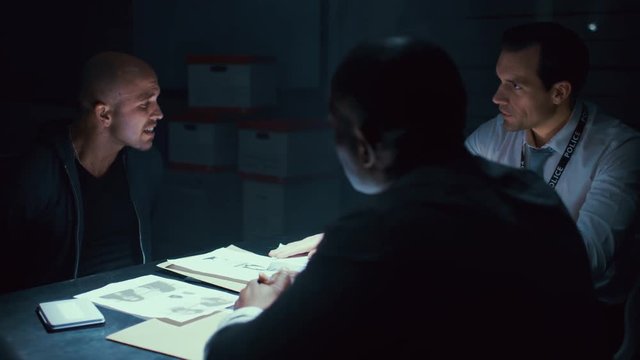  Detectives giving tough questioning to crime suspect at police station