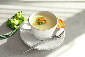Ceramic cup with potato cream soup on table
