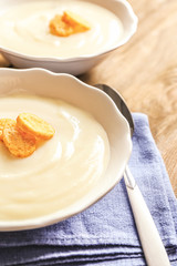 Potato cream soup in bowls on table