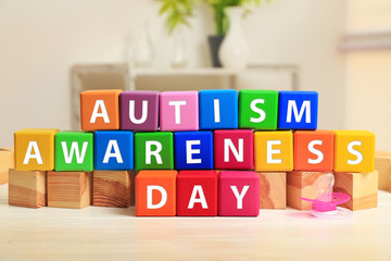 Cubes with text AUTISM SPECTRUM DAY on table