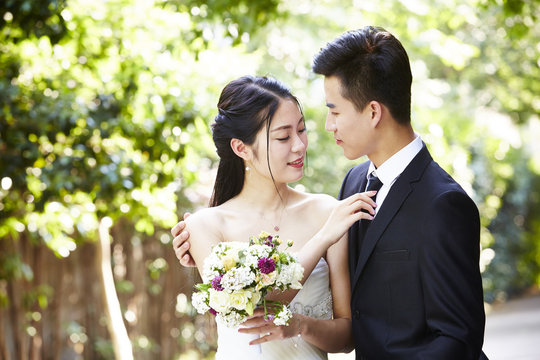 outdoor portrait of a newly-wed asian couple