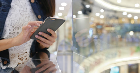 Woman working on mobile phone in shopping mall
