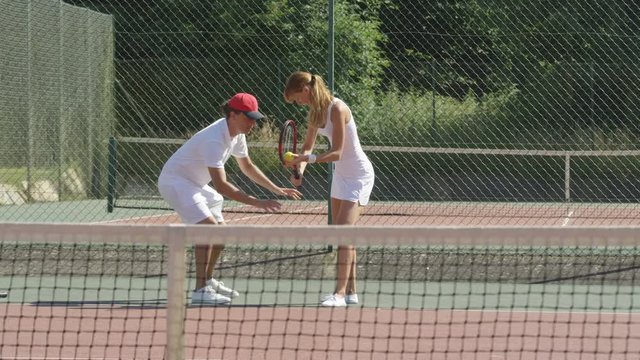  Female doubles tennis players enjoying a game on outdoor court in the summer