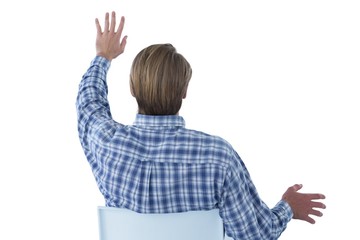 Rear view of businessman using imaginary interface while sitting