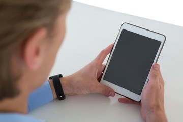 High angle view of businessman using tablet computer at table