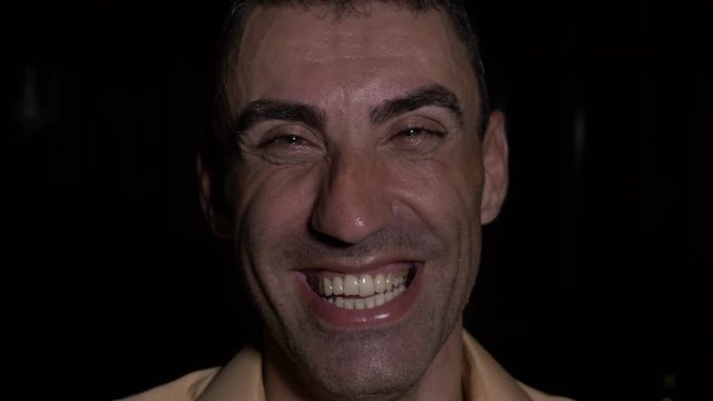 Portrait of a face of a laughing hilarious drunk man