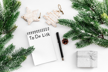 Make to do list for new year. Notebook among new year decorations on white background top view