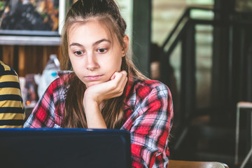 Beautiful student girl working on laptop.