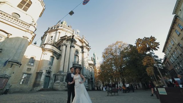 Lovely wedding couple stands near church in city Lviv, Ukraine