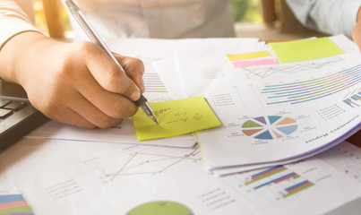 Close-up hand of businessman working on graph documents