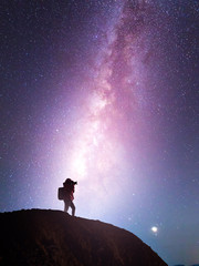 Fototapeta premium Silhouette of a camera girl who shooting a milky way