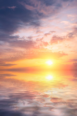 Beautiful sea sunset with bright sun and colorful clouds.