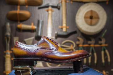 Vntage shoe with blurred vintage shoe making tools background.