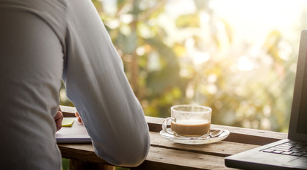 Close up coffee cup fo businessman on wooden desk at his home office