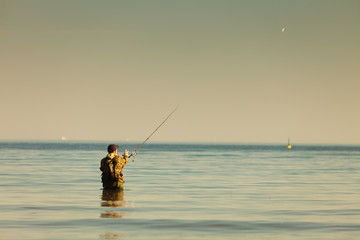 Man standing in water doing extreme fishing