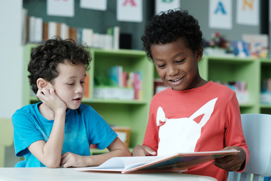 American and African boys are reading and studying together with happiness in their classroom, kid education concept