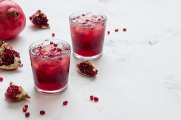 Pomegranat juice with ice and fruit slices, copy space