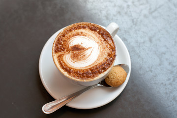 Cup of cappuccino with cookies on a table