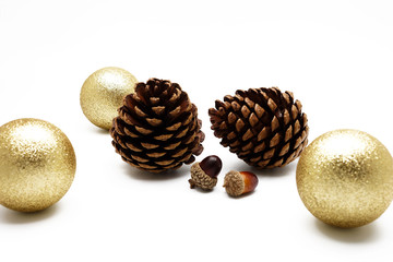 Pine cone and acorn with gold ball ornament on white background