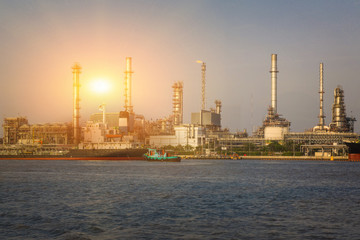 electric power generating factory, industry plant, chemical storage tanks and sunlight of sunset at evening near the river