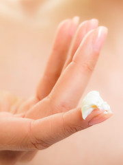 Skin care. Moisturizing cream on female finger