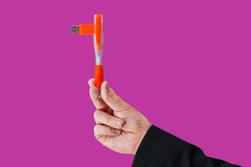 Pen flash memory on hand with isolated pink background