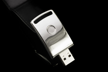 USB metal flash drive on black background. Silver color memory stick