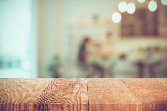empty wooden pallet table and blurred cafe or coffee shop, vintage tone, background for product display montage