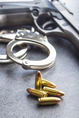 Pistol bullets, handgun and handcuffs.