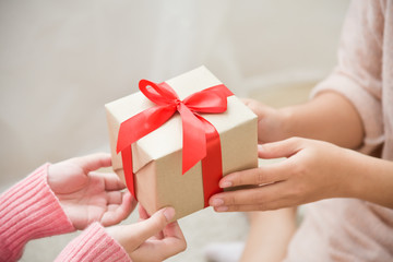 Asian woman hands giving a brown gift box.