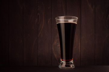Weizen beer glass porter or red ale on dark wood board, copy space. Template for advertising, design, branding identity, restaurant menu, cover.