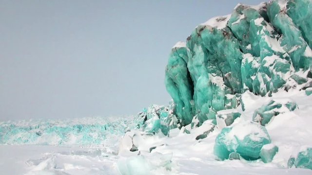 Glacier of beautiful unique turquoise color on background of snow in Arctic. Amazing ice desert landscape. Silence quiet of wilderness North Pole Way to Pyramid on Spitsbergen Svalbard in Norway.
