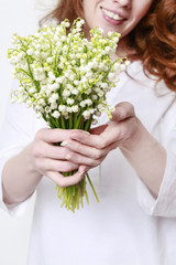 Woman holding bouquet of lily of the valley flowers