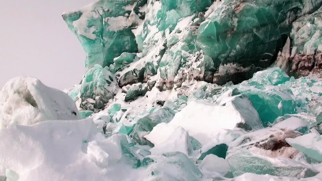 Glacier of beautiful unique turquoise color on background of snow in Arctic. Amazing ice desert landscape. Silence quiet of wilderness North Pole Way to Pyramid on Spitsbergen Svalbard in Norway.