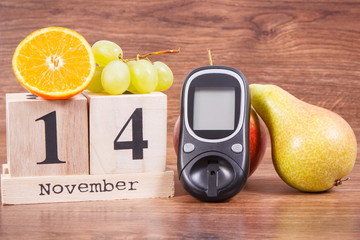 Date 14 November, glucose meter for checking sugar level and fruits, world diabetes day and fighting disease concept