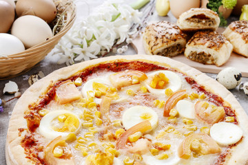 Pizza with eggs, cheese, corn and tomato.