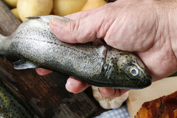 Cook holding a rainbow trout.